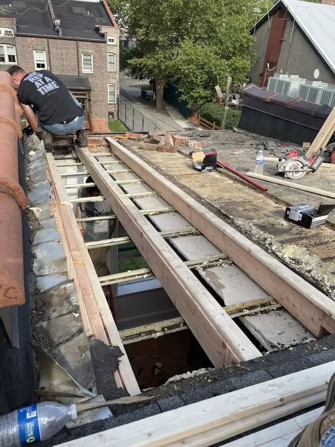 New wood roof framing installed over a brick rowhouse