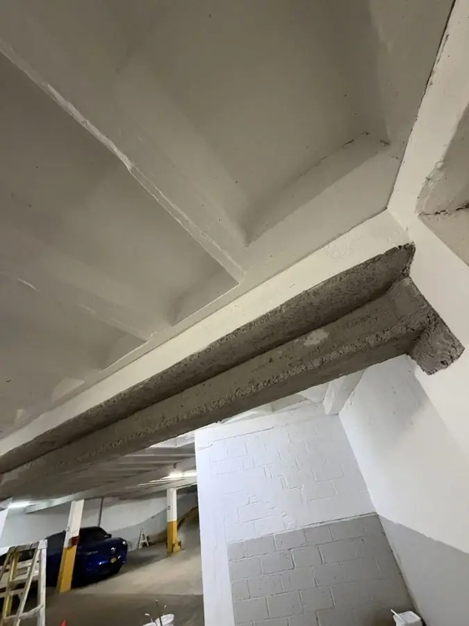 Restored garage beam with new fireproofed steel beam bolted underneath